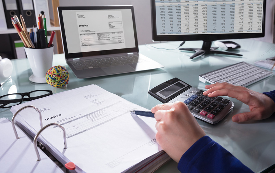 Desk with financial books, computer and calculator