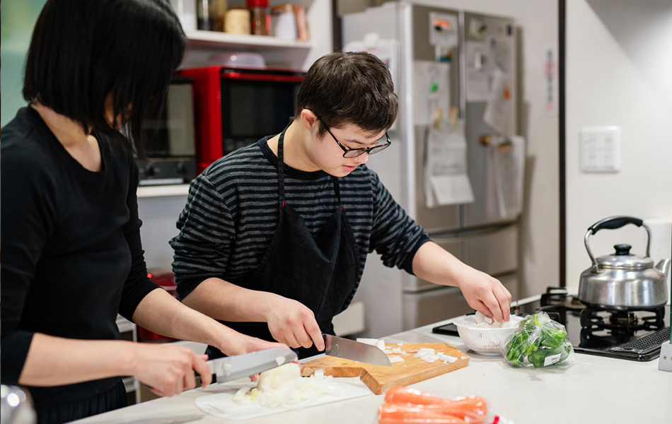 Young person learning to cook in kitchen
